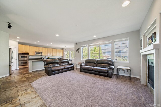 22227 E Hinsdale Ave, Aurora, CO 80016 - living room with recessed lighting, baseboards, a glass covered fireplace, and stone finish floors