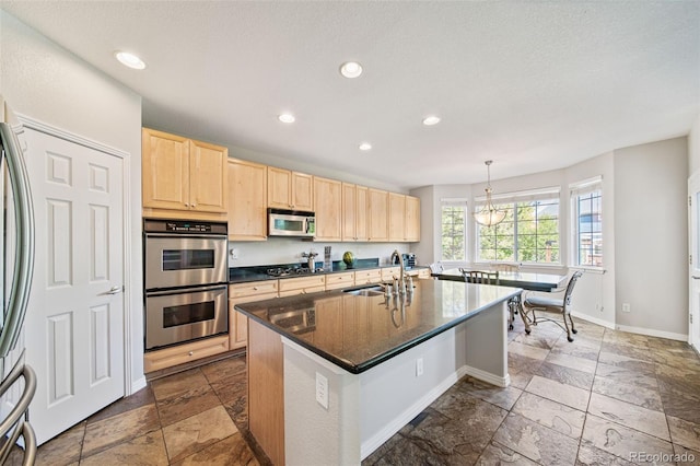 22227 E Hinsdale Ave, Aurora, CO 80016 - kitchen with light brown cabinetry, appliances with stainless steel finishes, a sink, stone tile floors, and baseboards
