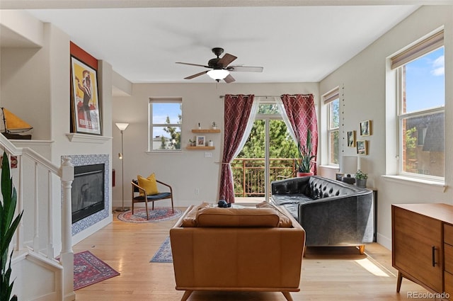7828 W 54th Ave, Arvada, CO 80002 - living room featuring light wood finished floors, ceiling fan, a fireplace, and baseboards