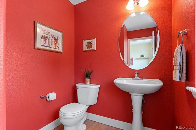 7828 W 54th Ave, Arvada, CO 80002 - bathroom with toilet, wood finished floors, and baseboards