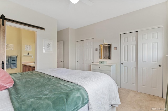 7828 W 54th Ave, Arvada, CO 80002 - bedroom featuring multiple closets, a barn door, light carpet, and a ceiling fan