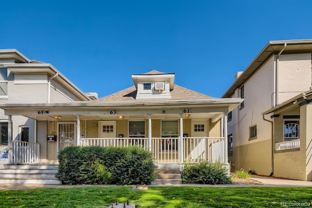 view of front facade with a front yard and covered porch