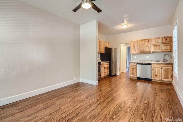 kitchen featuring sink, dark hardwood / wood-style floors, ceiling fan, appliances with stainless steel finishes, and light brown cabinetry