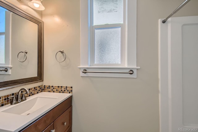 bathroom with tasteful backsplash, vanity, and a shower