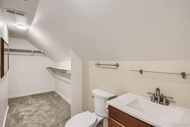 bathroom with vanity, toilet, and lofted ceiling