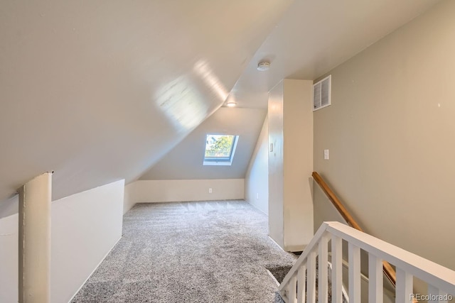 bonus room featuring vaulted ceiling with skylight and carpet