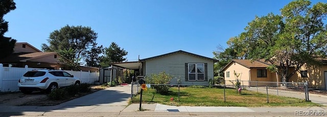 view of front of home with a front lawn, a shed, and a carport