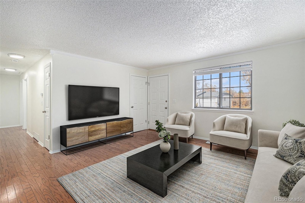 living room with wood-type flooring and a textured ceiling