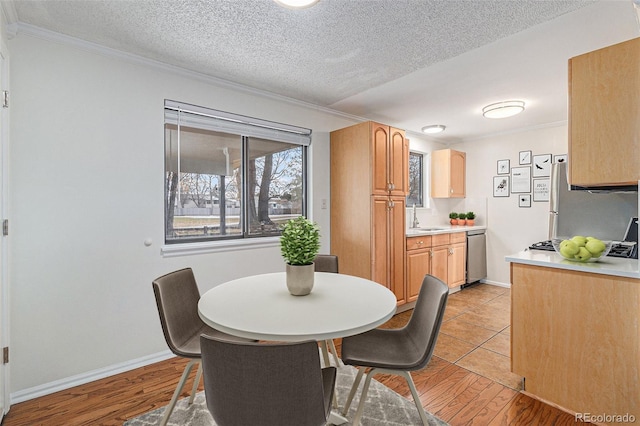 dining space with a textured ceiling, crown molding, and sink