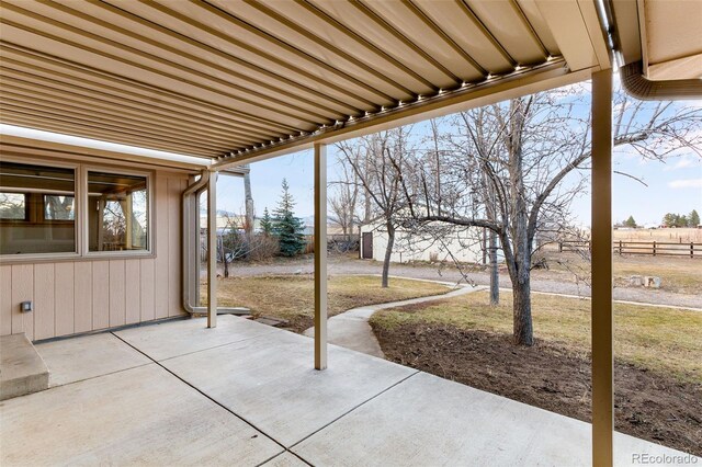 view of patio / terrace with an outdoor structure and fence