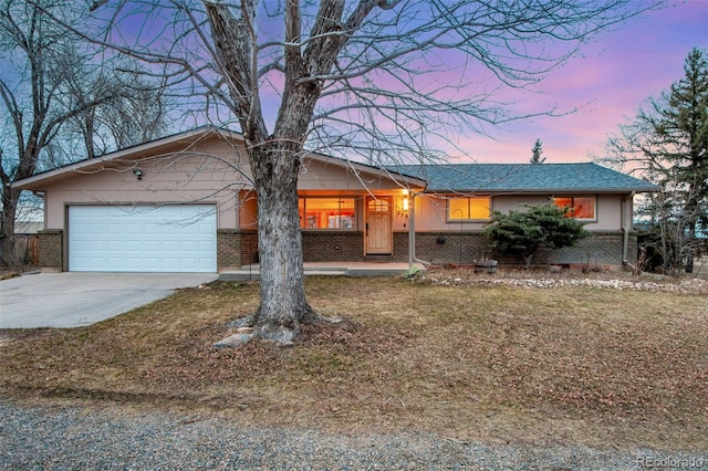 ranch-style house with a garage, brick siding, and driveway