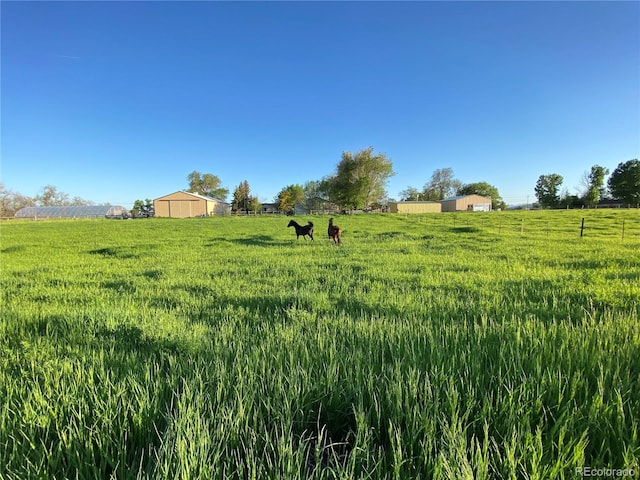 view of yard with a rural view and fence