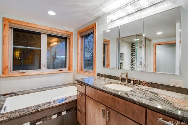 full bath featuring a garden tub and vanity