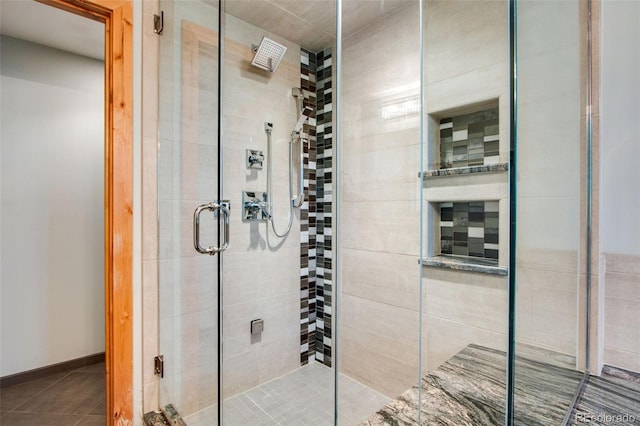 bathroom featuring a shower stall and baseboards