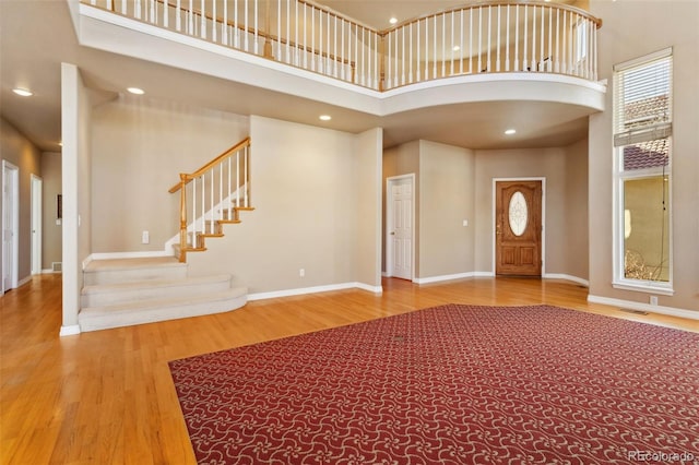 entrance foyer featuring hardwood / wood-style flooring and a towering ceiling