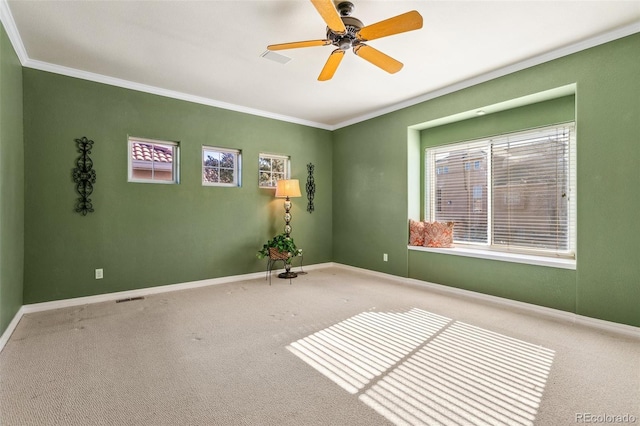 carpeted spare room featuring crown molding and ceiling fan