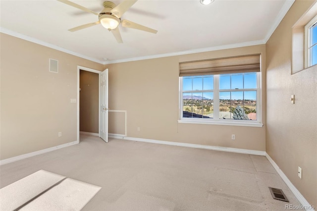 empty room featuring crown molding, ceiling fan, and carpet