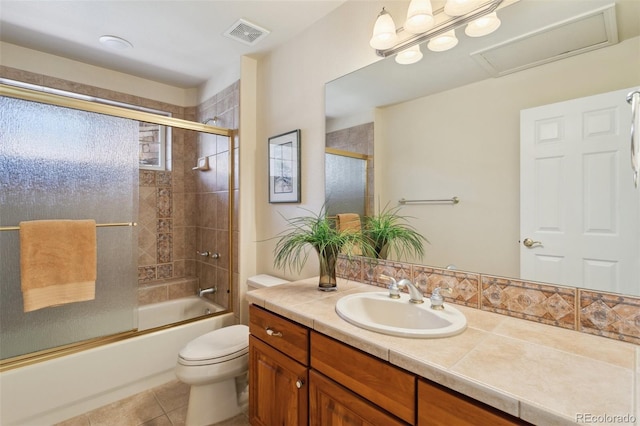 full bathroom with tile patterned flooring, vanity, shower / bath combination with glass door, and toilet