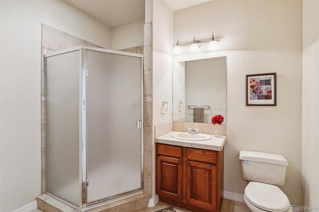 bathroom with toilet, vanity, and a shower with shower door