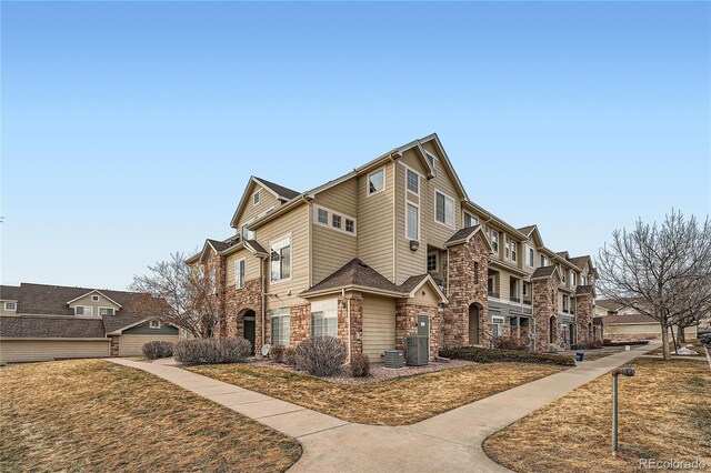 view of front of property with a front yard and central air condition unit