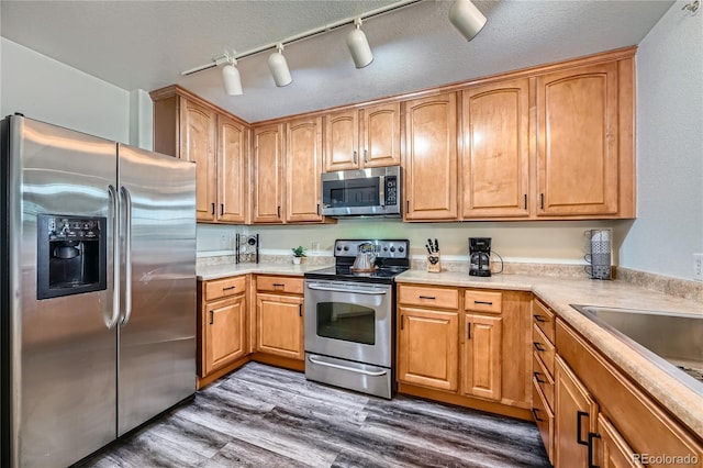 kitchen with dark wood-type flooring, appliances with stainless steel finishes, and a textured ceiling