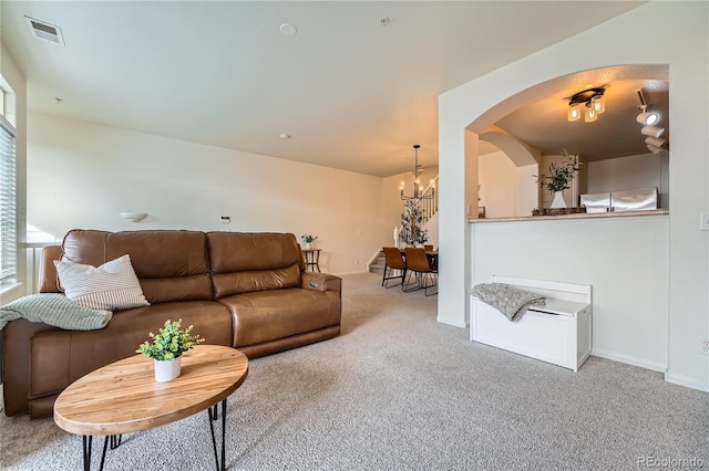 carpeted living room featuring a chandelier