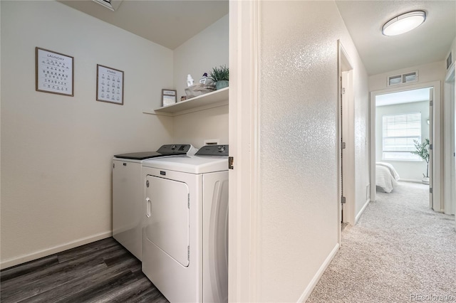 laundry area with laundry area, wood finished floors, visible vents, baseboards, and washer and clothes dryer