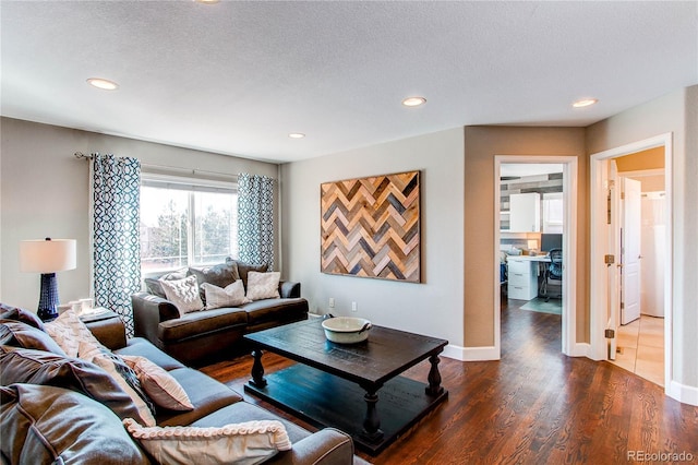 living area with dark wood-style floors, baseboards, a textured ceiling, and recessed lighting