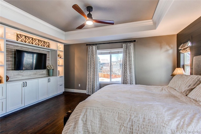 bedroom with baseboards, a tray ceiling, dark wood-type flooring, and crown molding