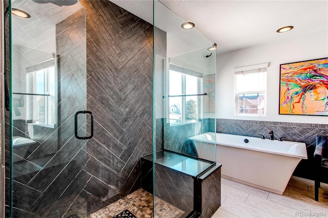 full bath with a freestanding bath, a stall shower, tile walls, and recessed lighting