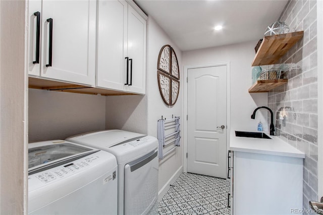 clothes washing area featuring washer and dryer, cabinet space, a sink, and recessed lighting