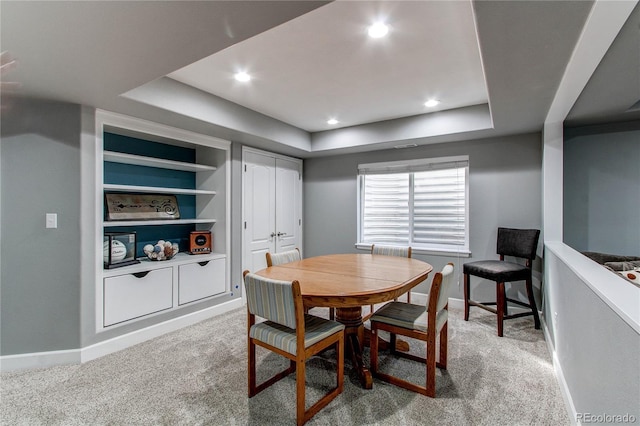 carpeted dining area featuring recessed lighting, a raised ceiling, built in features, and baseboards