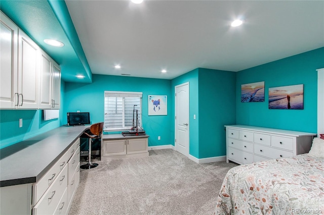 bedroom with light carpet, baseboards, built in desk, and recessed lighting