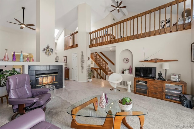 carpeted living room featuring ceiling fan, a tile fireplace, and high vaulted ceiling