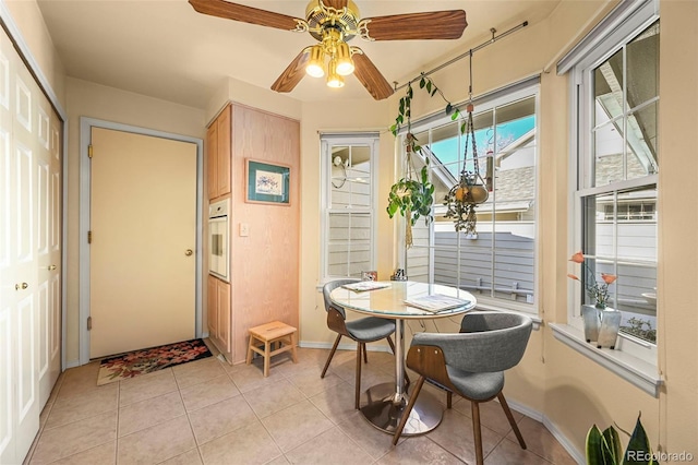 dining space with light tile patterned floors and ceiling fan