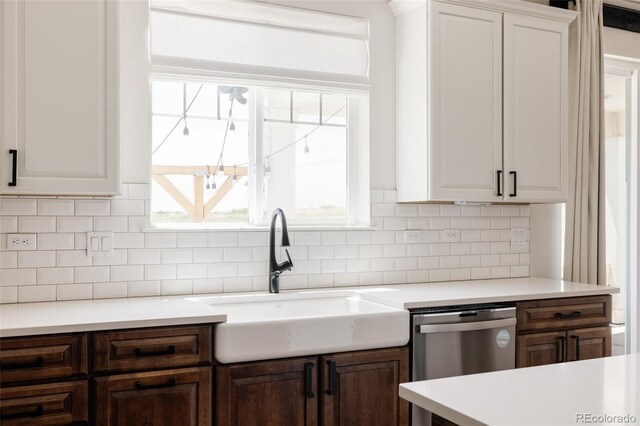 5840 Longs Peak St, Brighton, CO 80601 - kitchen with stainless steel dishwasher, light countertops, backsplash, white cabinetry, and dark brown cabinetry