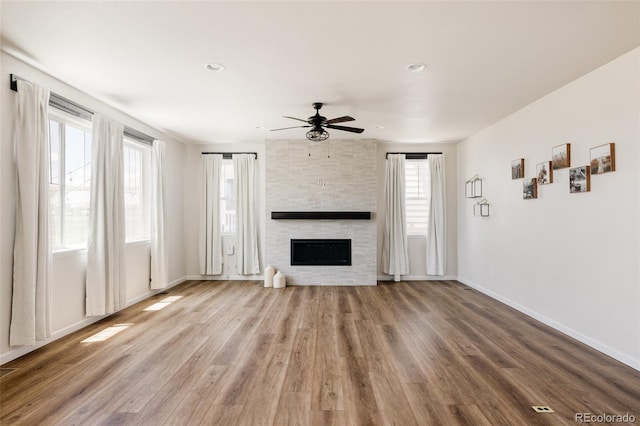 5840 Longs Peak St, Brighton, CO 80601 - unfurnished living room featuring ceiling fan, wood finished floors, a large fireplace, and recessed lighting