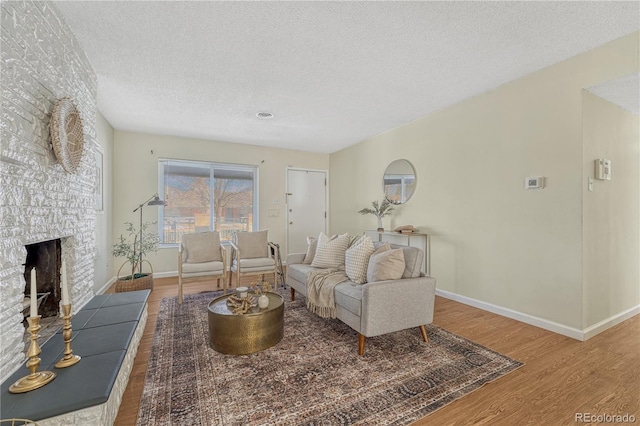 living room with a fireplace, hardwood / wood-style floors, and a textured ceiling