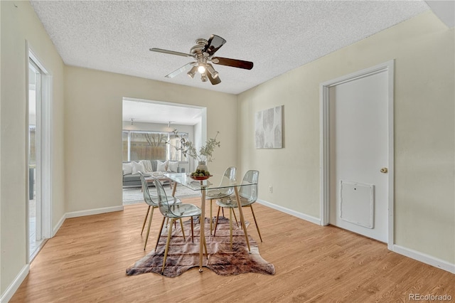 dining space with ceiling fan, a textured ceiling, and light hardwood / wood-style flooring