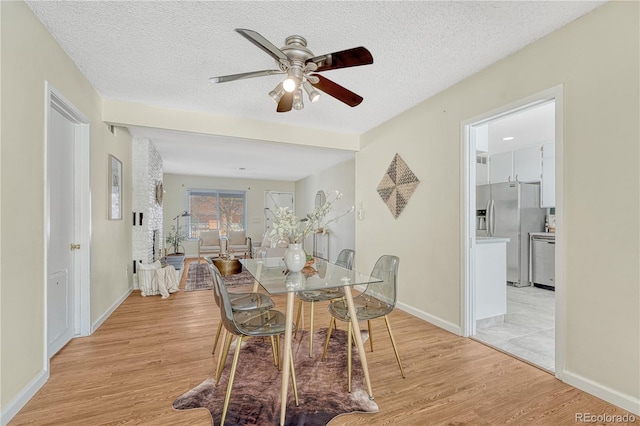 dining room featuring ceiling fan, a textured ceiling, and light wood-type flooring