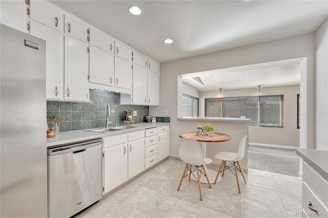 kitchen featuring sink, stainless steel dishwasher, white cabinets, and backsplash