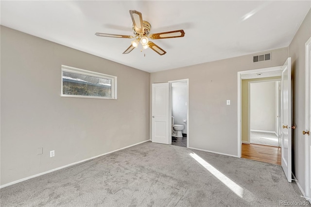 unfurnished bedroom with ceiling fan, connected bathroom, and light carpet