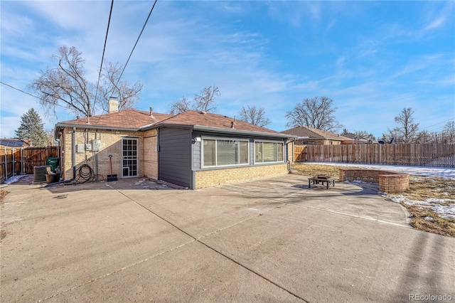 back of house featuring central AC unit, a fire pit, and a patio