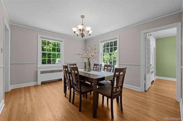 1033 Estes St, Lakewood, CO 80215 - dining area with radiator heating unit, a chandelier, ornamental molding, and light wood-style flooring