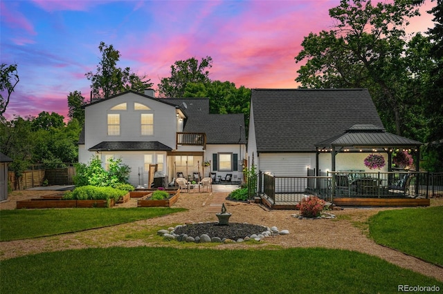 1033 Estes St, Lakewood, CO 80215 - rear view of property featuring a gazebo, a vegetable garden, a shingled roof, and a balcony