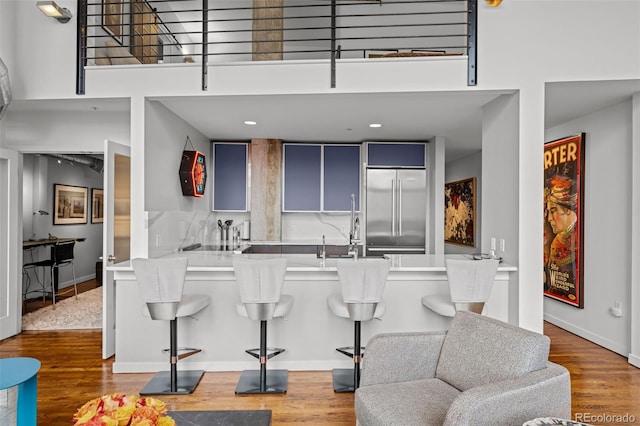 1050 Cherokee St Unit 403, Denver, CO 80204 - kitchen featuring built in refrigerator, a towering ceiling, a peninsula, wood finished floors, and a sink