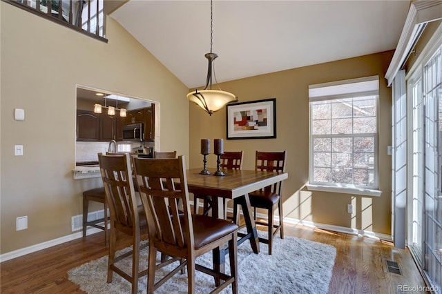 dining area with wood finished floors, a healthy amount of sunlight, and visible vents