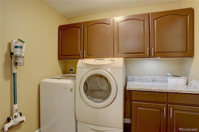 washroom with washer and clothes dryer and cabinet space