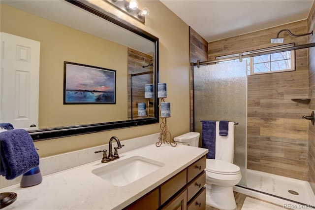 bathroom with toilet, a stall shower, and vanity