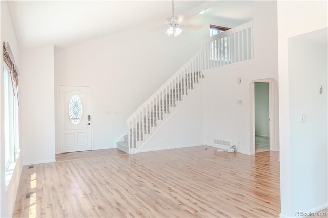 7978 S Johnson Ct, Littleton, CO 80128 - foyer with high vaulted ceiling, stairway, light wood-style flooring, ceiling fan, and arched walkways